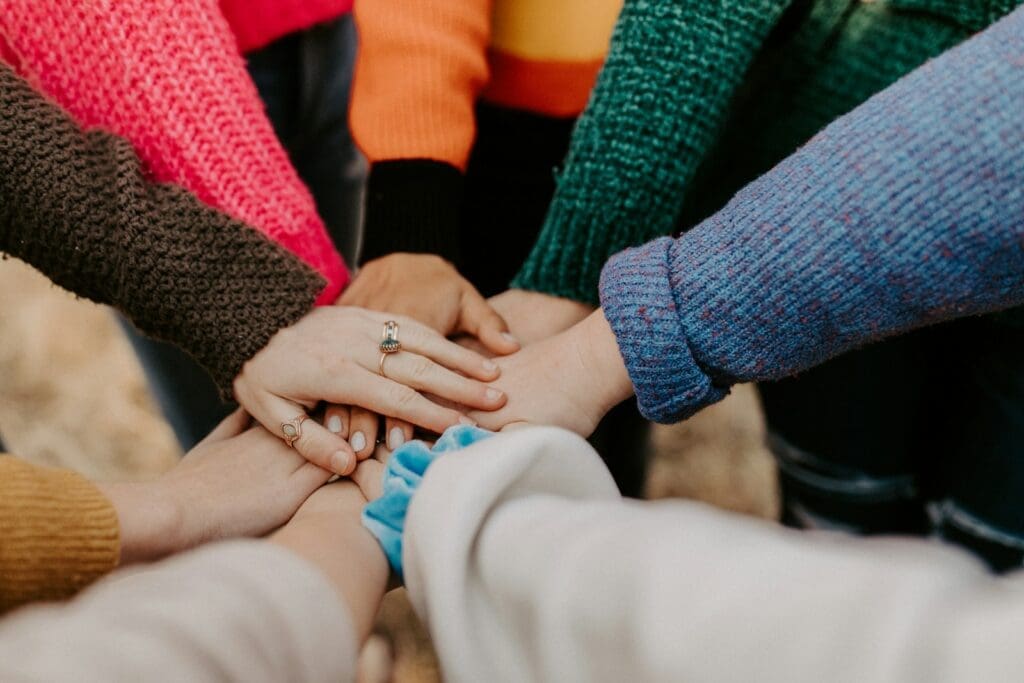 team person in red sweater holding babys hand